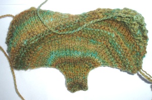 The unblocked Either Or Mitten twists and turns a bit. The different knit directions and the change in stockinette and garter stitch makes it twist.